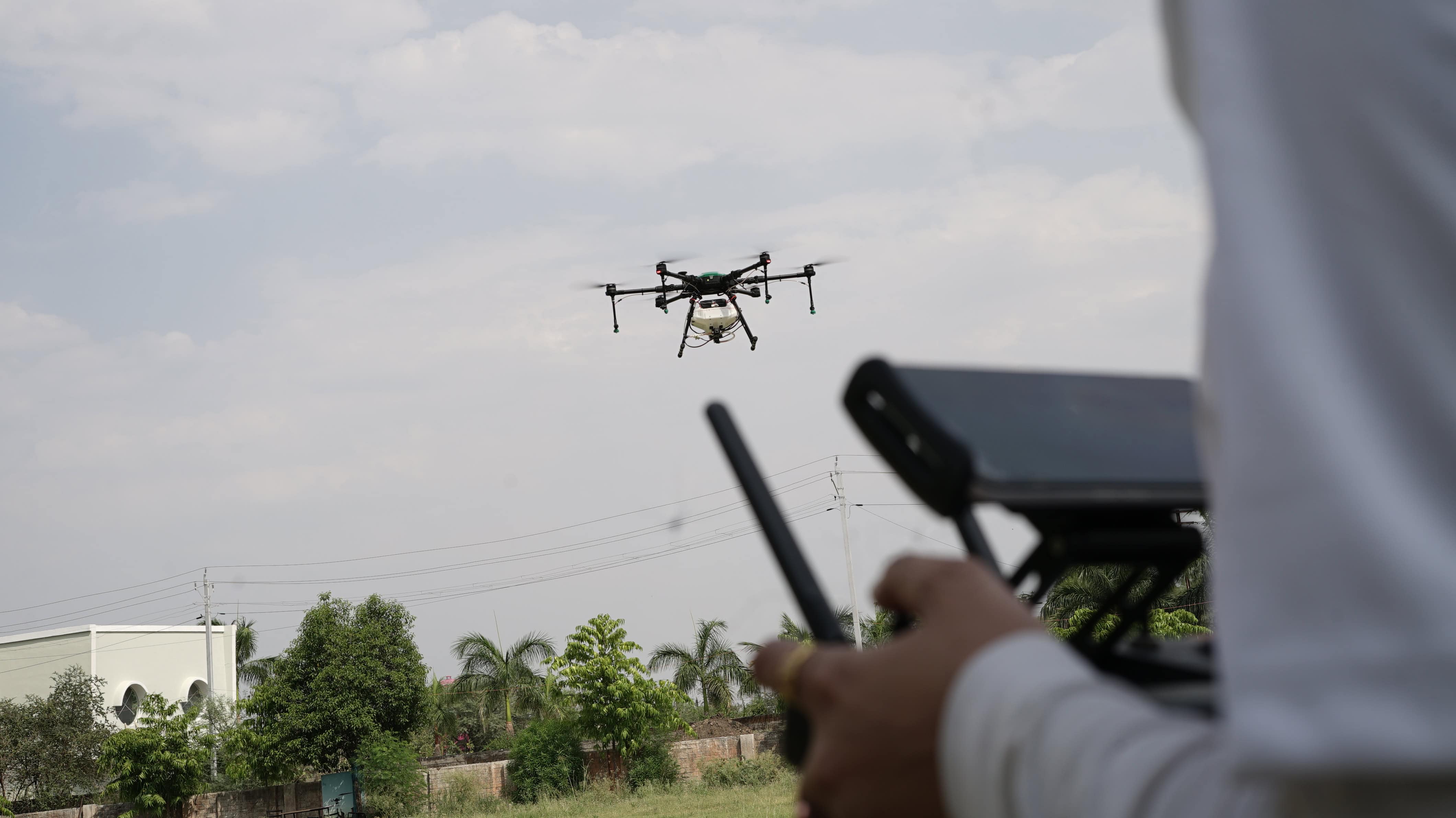 Shakti drone in flight beyond its handheld controller